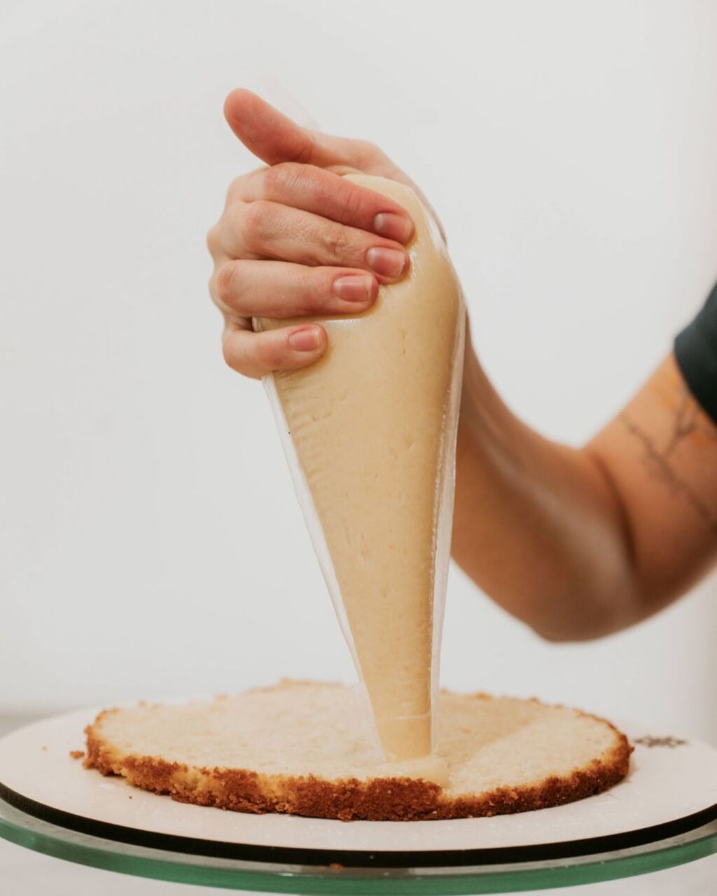 Luiza aplicando recheio em um bolo de aniversário